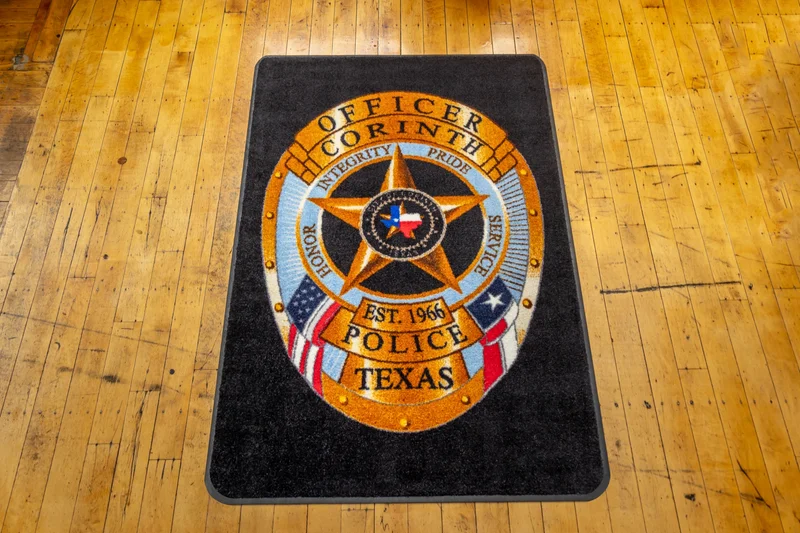 Custom logo mat with photographic-quality artwork on a wood floor