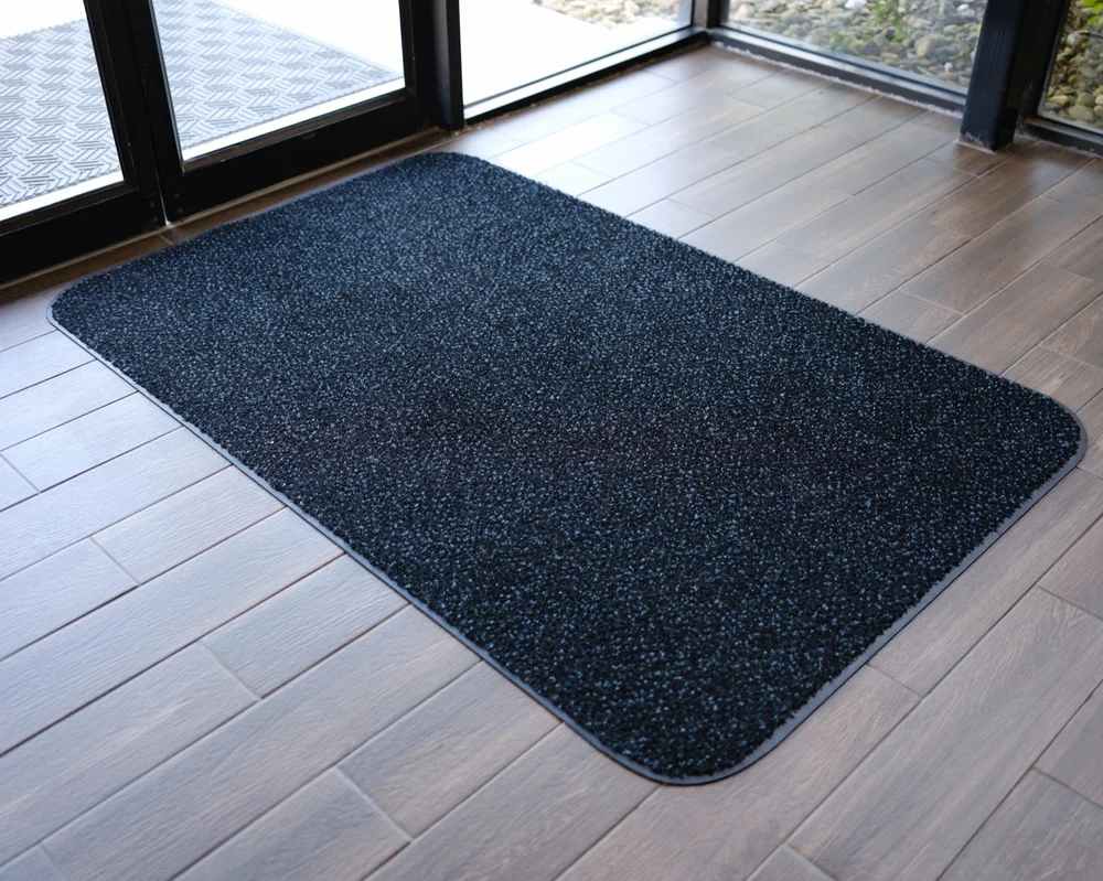 Mats That Matter entrance mat placed inside a glass doorway