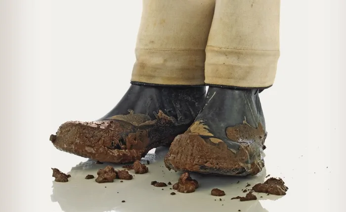 Mud-caked boots dropping clumps of dirt