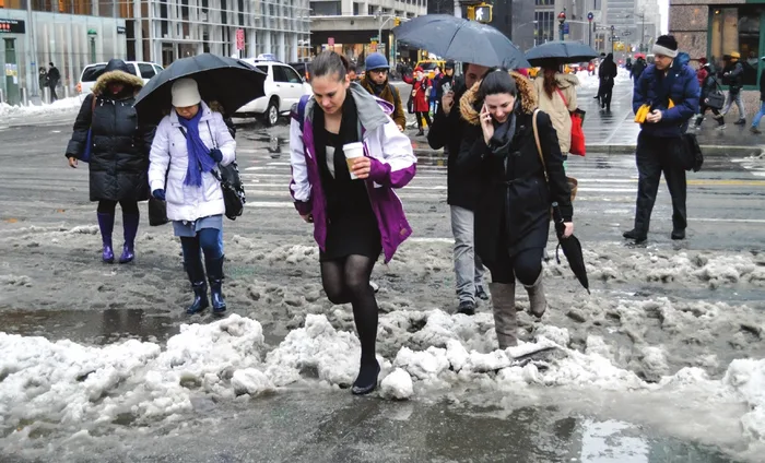Pedestrians crossing a slushy snow-covered street